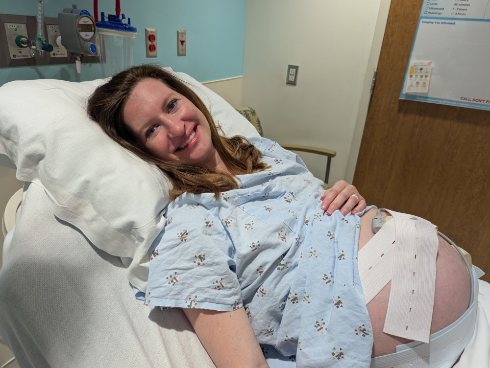 a pregnant woman, Amanda Reichart, smiling in the delivery room