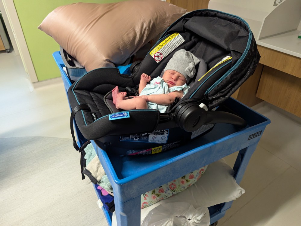 baby Vienna Reichart in a child seat on a hospital cart
