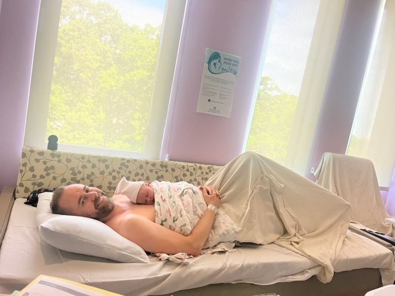 Shane Reichart in the hospital with baby Vienna Reichart on his chest